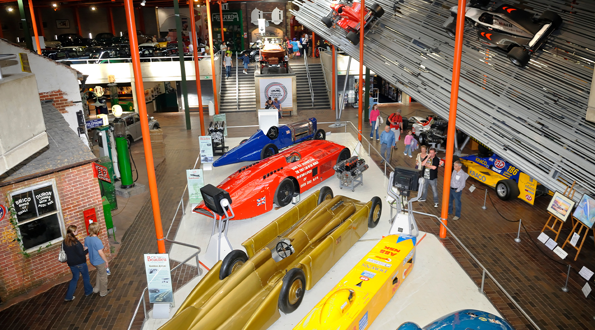 Bovenaanzicht van historische raceauto’s in industrieel gebouw